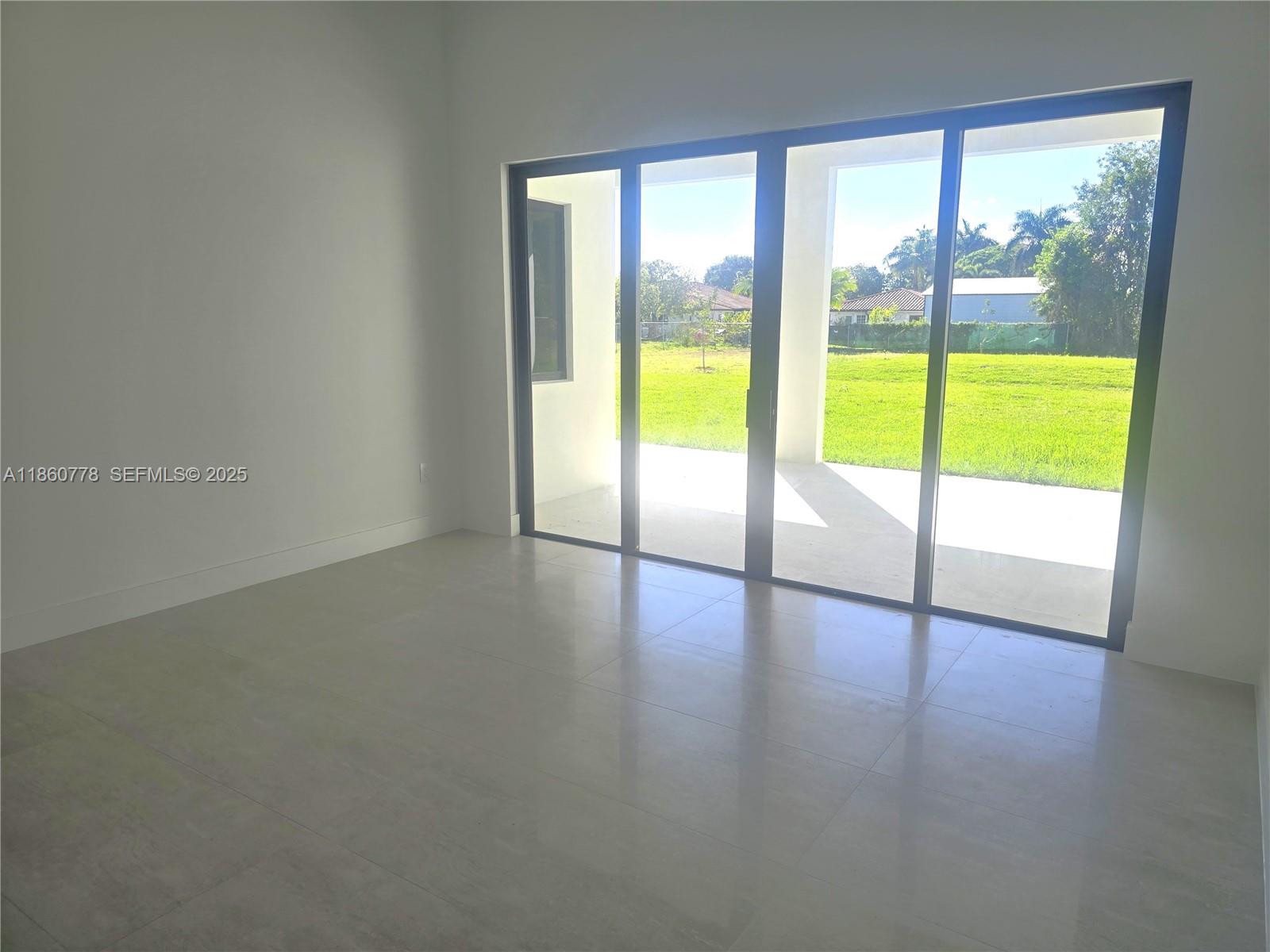 23840 Southwest 209th Place Homestead, FL 33031 - Photo 29 of 89 a view of an empty room with wooden floor and a window