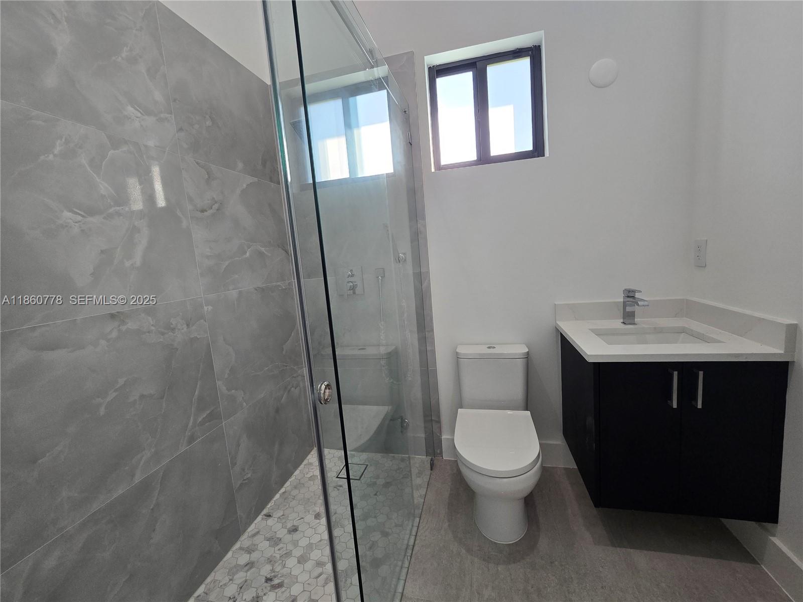 23840 Southwest 209th Place Homestead, FL 33031 - Photo 32 of 89 a bathroom with a toilet a sink and mirror