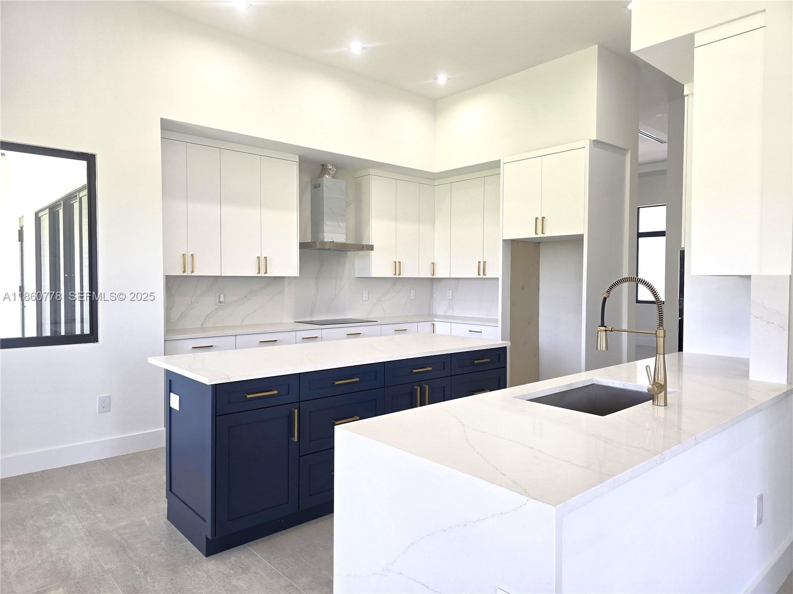 23840 Southwest 209th Place Homestead, FL 33031 - Photo 40 of 89 a kitchen with a sink a stove a refrigerator and white cabinets