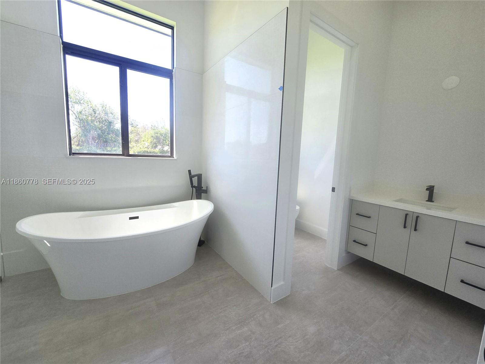 23840 Southwest 209th Place Homestead, FL 33031 - Photo 73 of 89 a spacious bathroom with a bathtub and a window