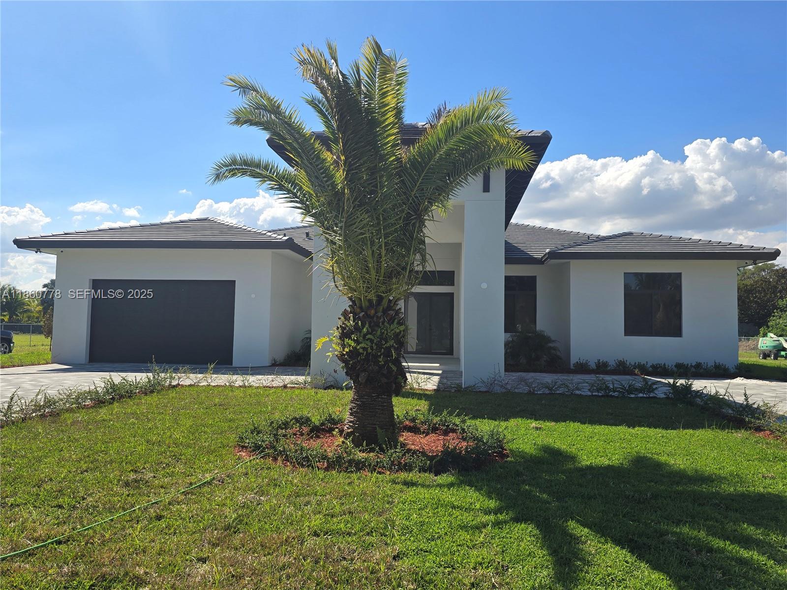 23840 Southwest 209th Place Homestead, FL 33031 - Photo 10 of 89 a front view of a house with a garden and trees