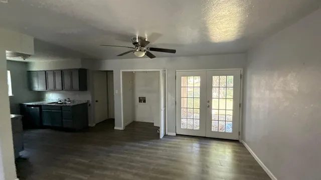 a large kitchen with stainless steel appliances granite countertop a stove and a large window