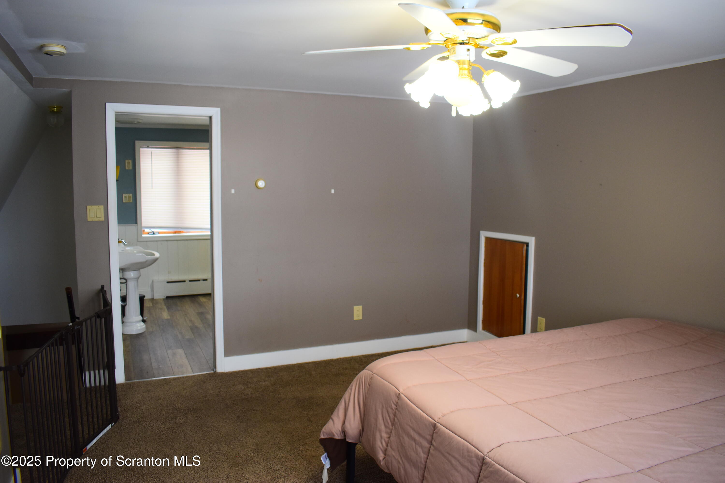 3003 Ridge Road Thompson, PA 18465 - Photo 15 of 33 a bedroom with a bed and a chandelier