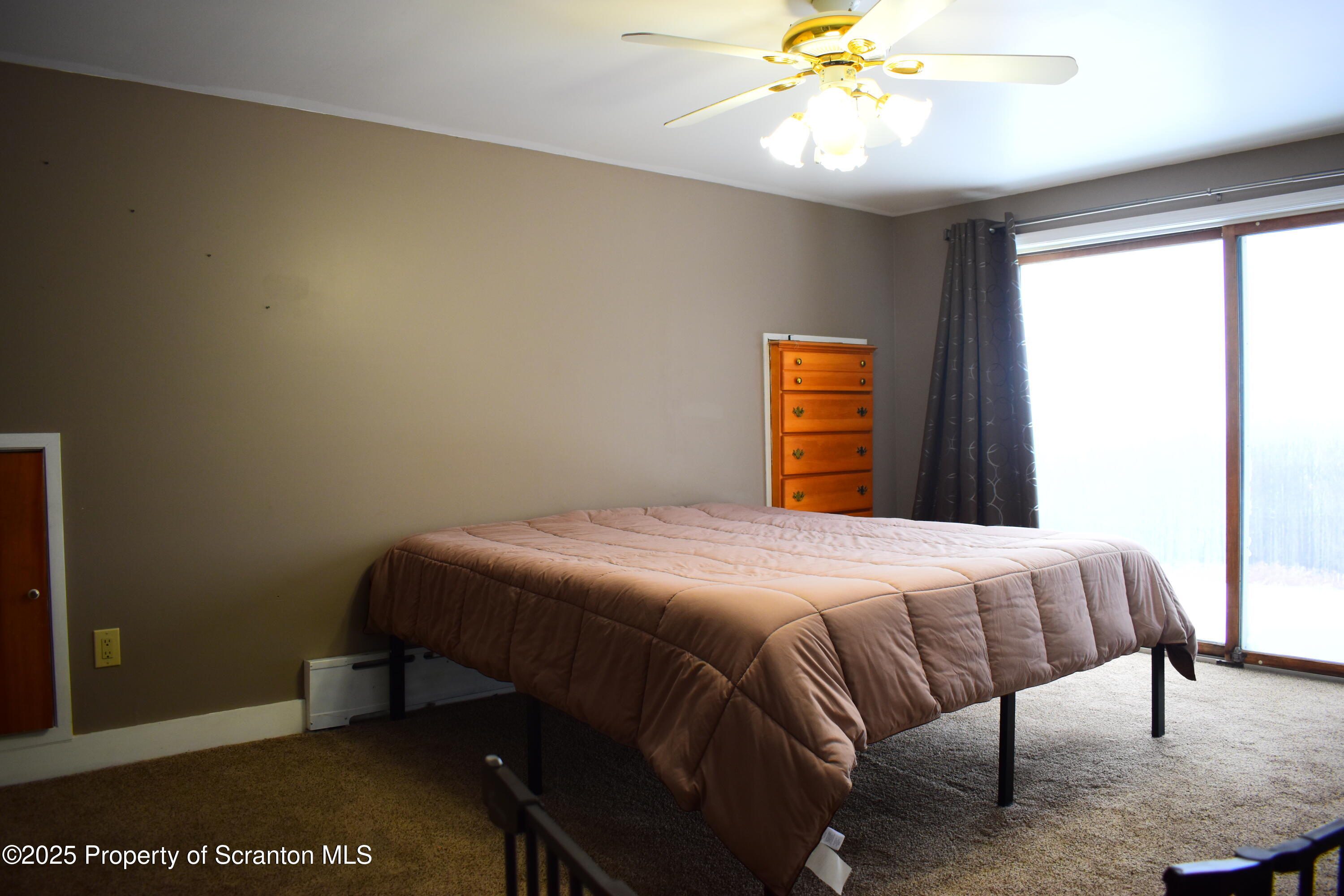 3003 Ridge Road Thompson, PA 18465 - Photo 16 of 33 a bedroom with a bed and a chandelier