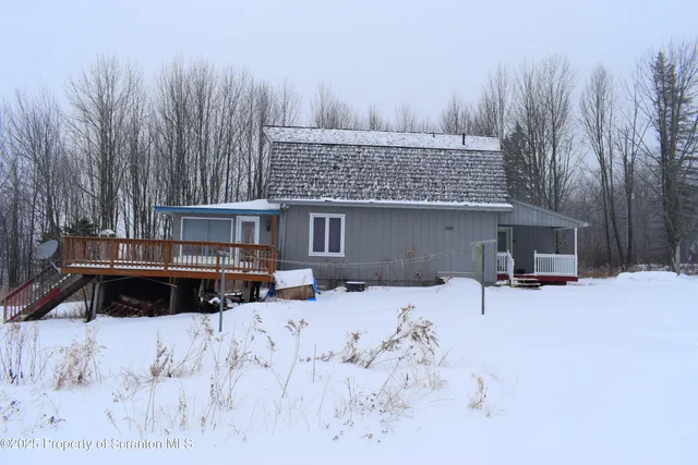 a view of a house with a yard covered in snow