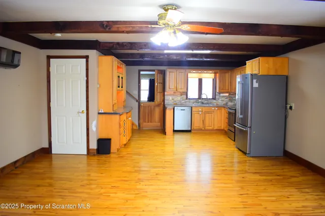a view of an empty room with a kitchen