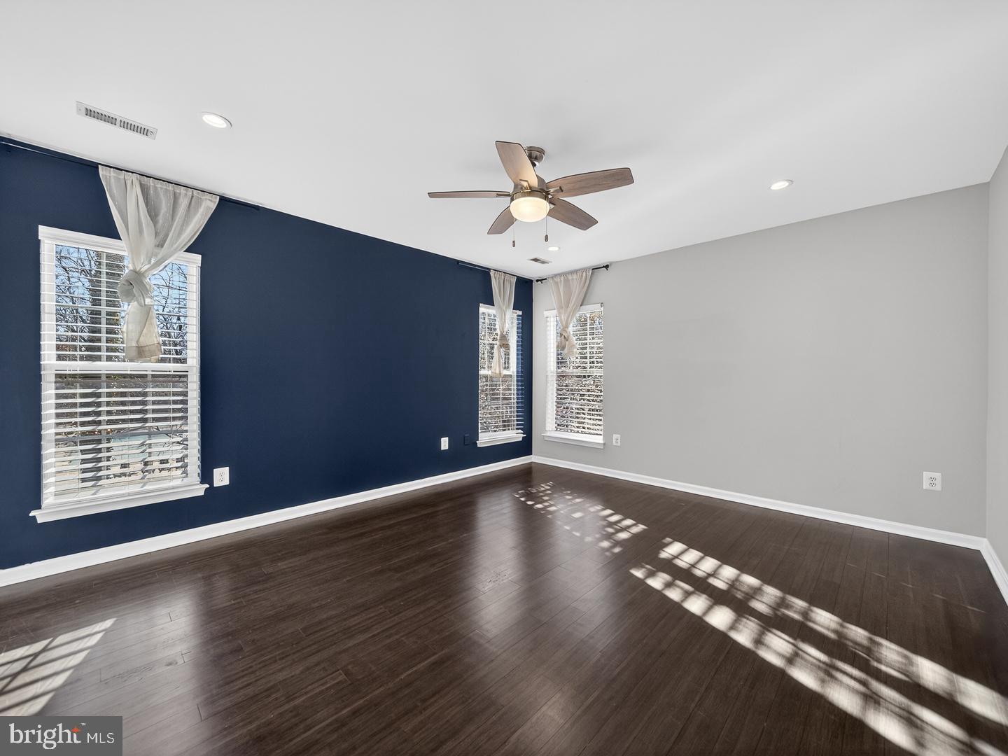 9534 Fernwood Road Bethesda, MD 20817 - Photo 10 of 44 a view of an empty room with chandelier fan and wooden floor