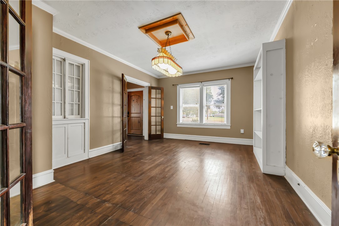800 South Ennis Street Bryan, TX 77803 - Photo 14 of 38 an empty room with wooden floor chandelier and windows
