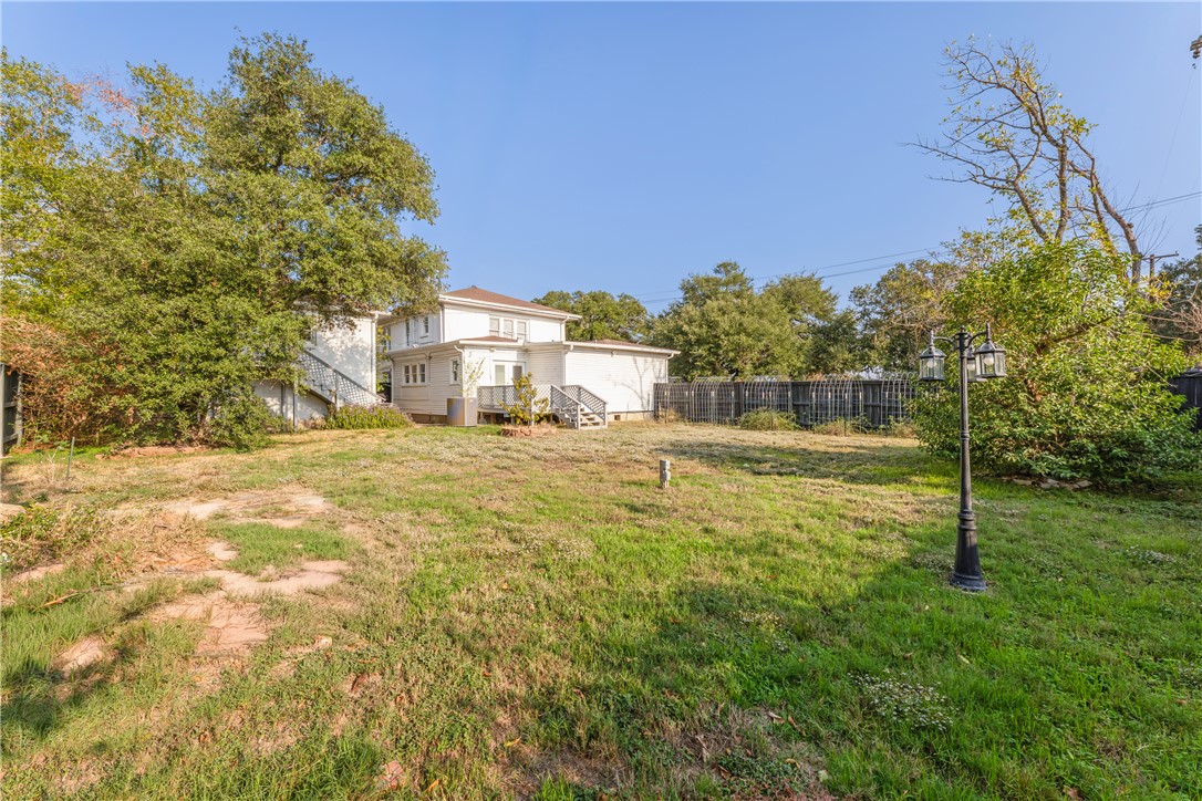 800 South Ennis Street Bryan, TX 77803 - Photo 31 of 38 a view of a large yard with plants and a building in the background