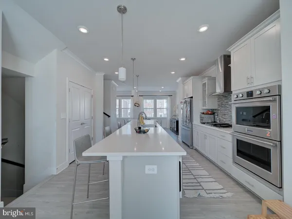 a kitchen with kitchen island a sink stainless steel appliances and cabinets