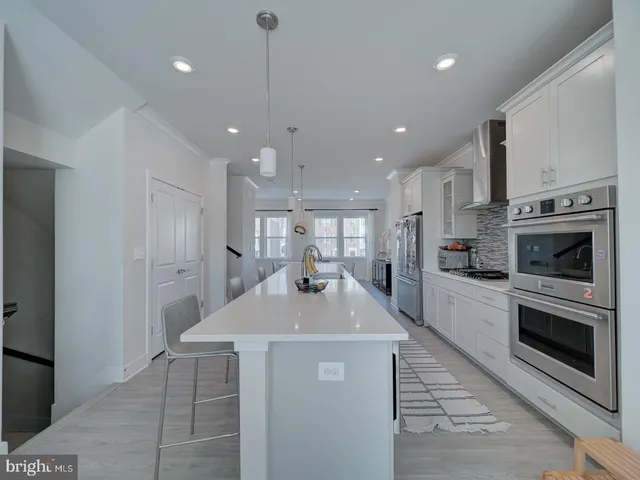 a kitchen with kitchen island a sink stainless steel appliances and cabinets