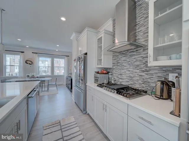 a kitchen with stainless steel appliances kitchen island granite countertop a stove a sink dishwasher and cabinets