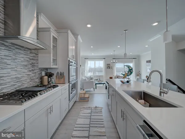 a kitchen with stainless steel appliances a sink stove and cabinets