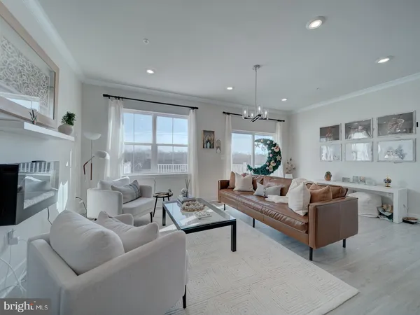 a living room with furniture fireplace and a large window