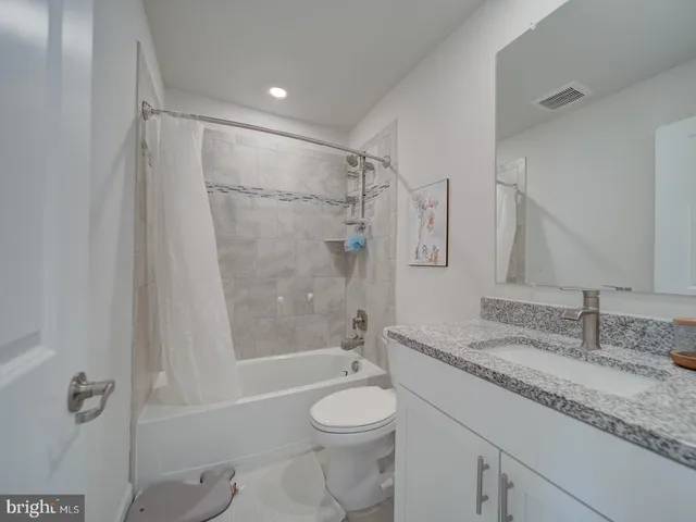 a bathroom with a granite countertop sink toilet and shower
