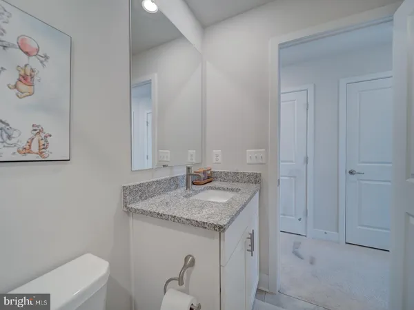 a bathroom with a granite countertop sink and a mirror