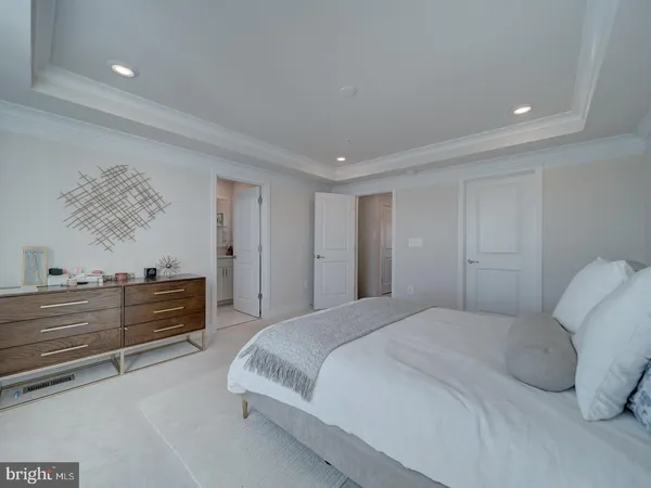 a spacious bedroom with a bed and a dresser