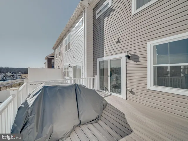 a view of a house with a barbeque and wooden stairs