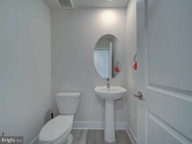 a room with a toilet a sink and a mirror