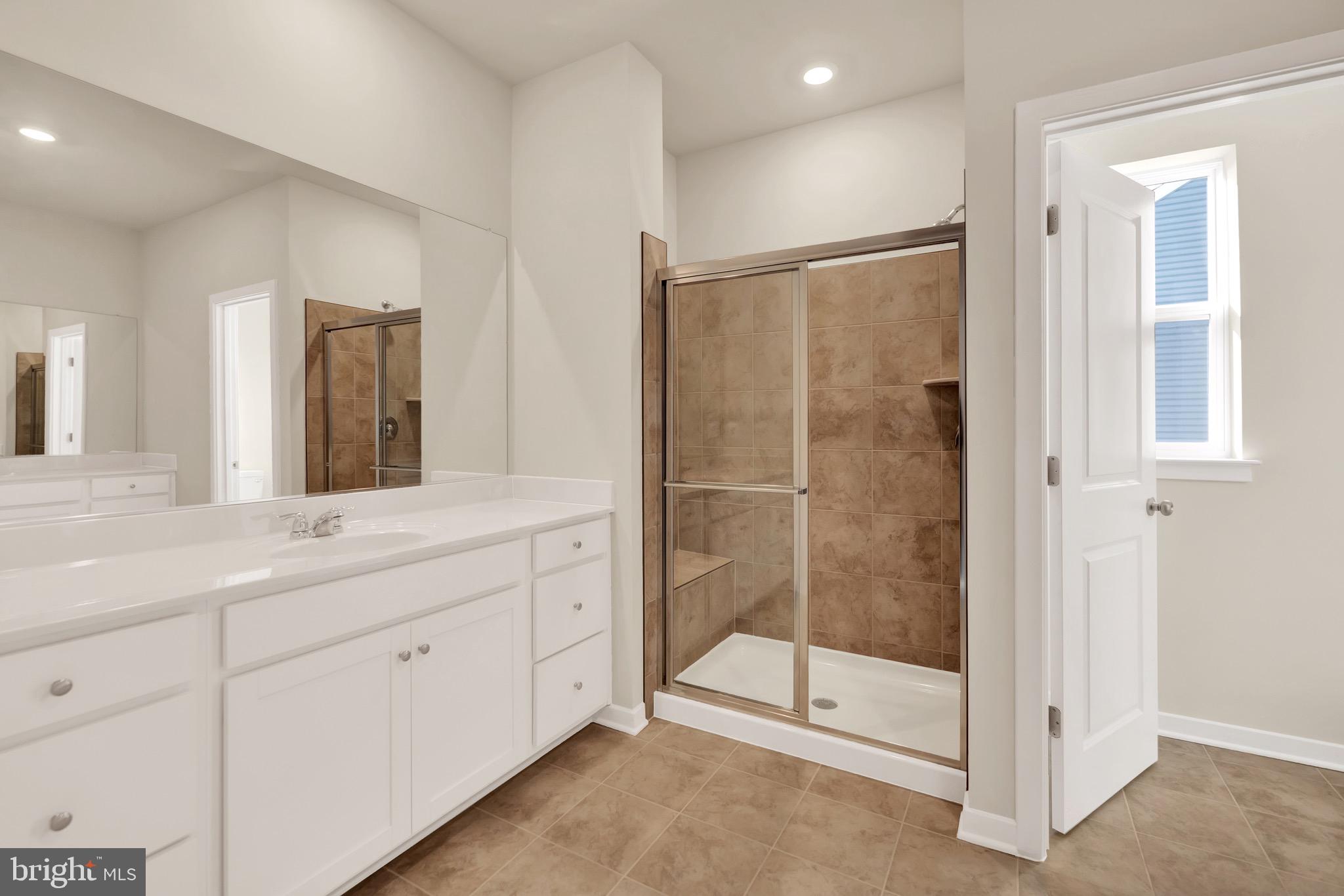 614 Mountain Laurel Boulevard Ranson, WV 25438 - Photo 22 of 28 a spacious bathroom with a shower sink and mirror