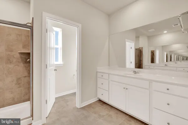 a spacious bathroom with a double vanity sink and a mirror