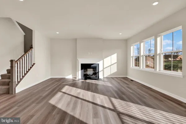a view of a livingroom with wooden floor and a fireplace