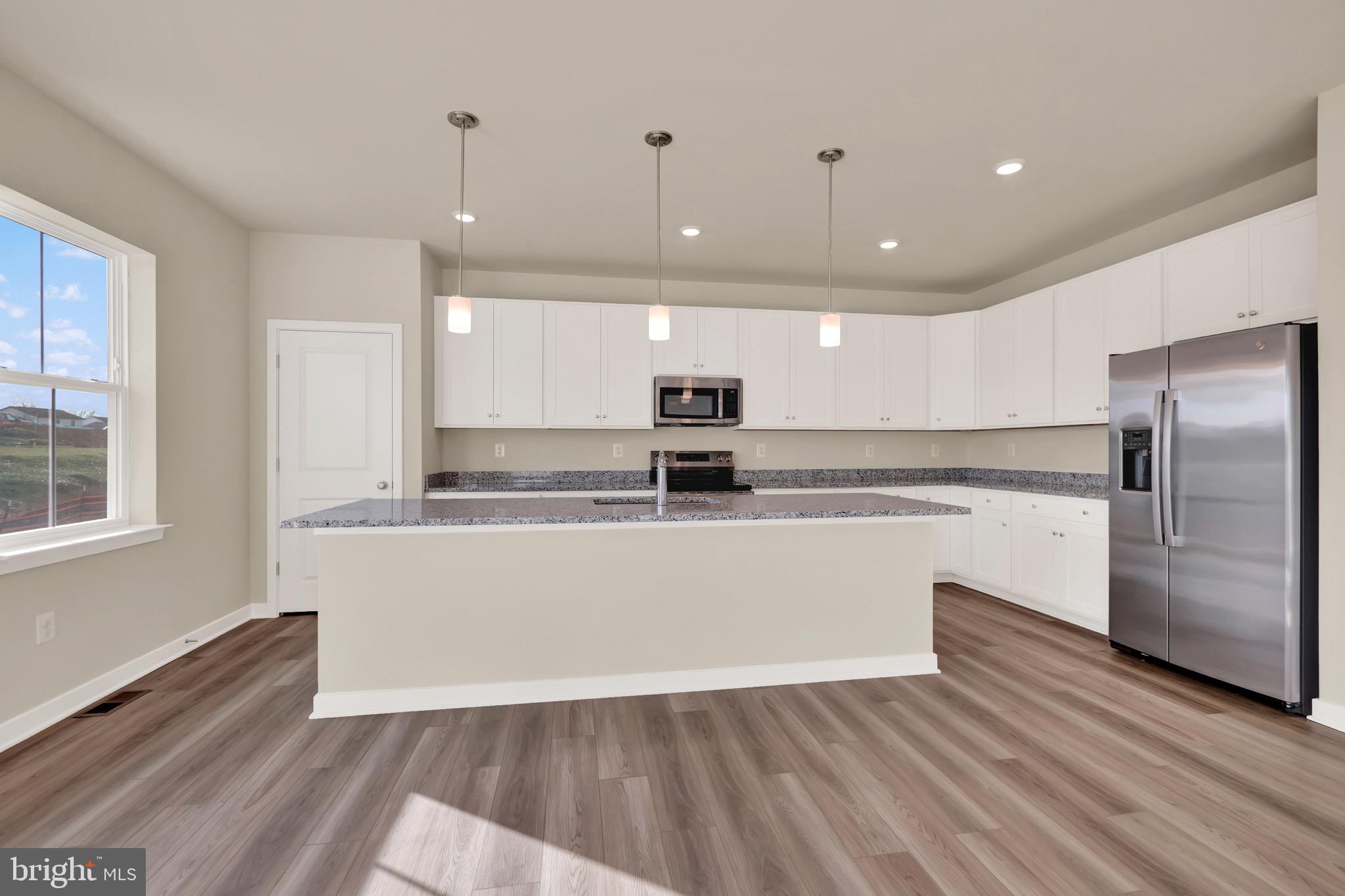 614 Mountain Laurel Boulevard Ranson, WV 25438 - Photo 9 of 28 a large kitchen with stainless steel appliances granite countertop a large counter top a sink and a refrigerator