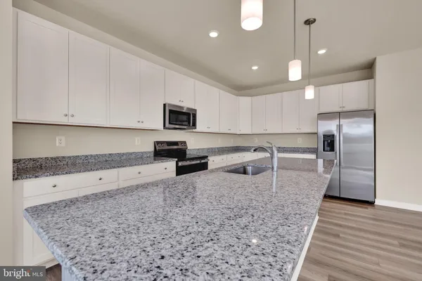 a kitchen with stainless steel appliances granite countertop a sink refrigerator and microwave