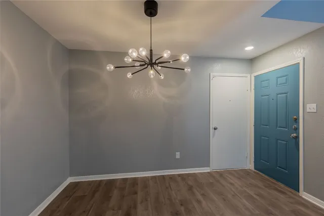 a view of an empty room with a chandelier fan