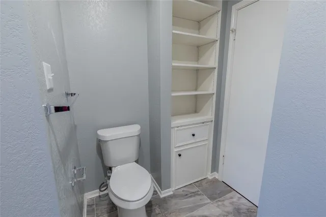 a white toilet sitting next to a bathroom sink