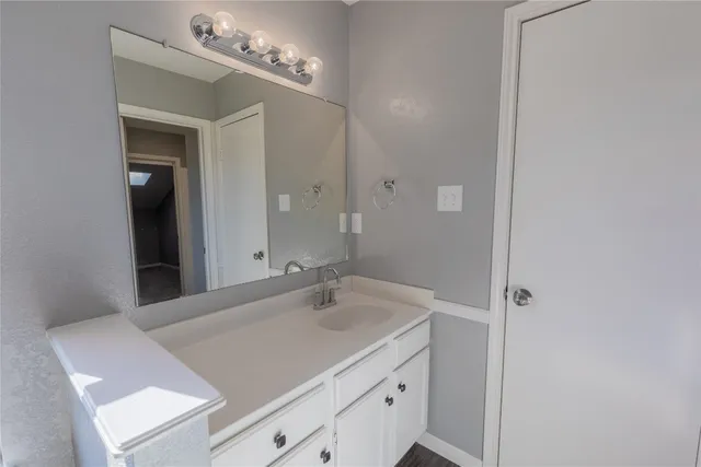 a bathroom with a sink vanity and a mirror