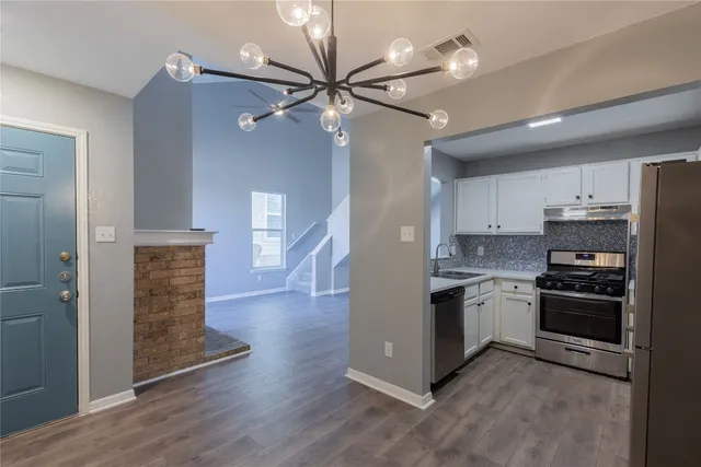 a kitchen with stainless steel appliances granite countertop a stove a refrigerator and a sink