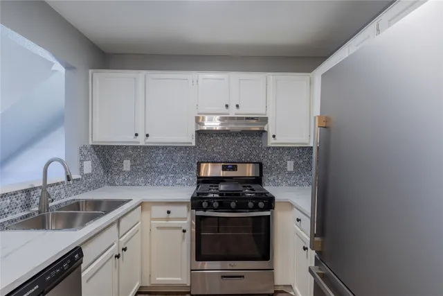 a kitchen with sink a stove and cabinets
