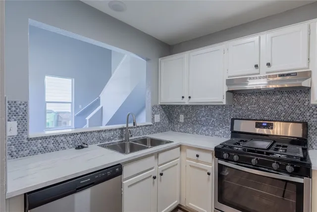 a kitchen with a sink stove and cabinets