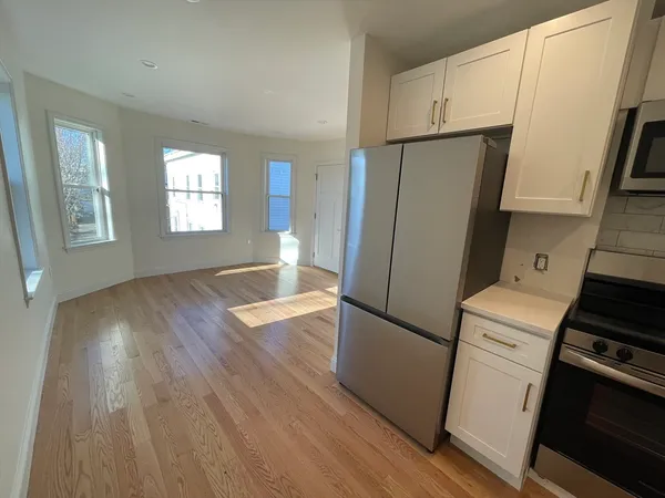 a kitchen with a refrigerator and a stove top oven