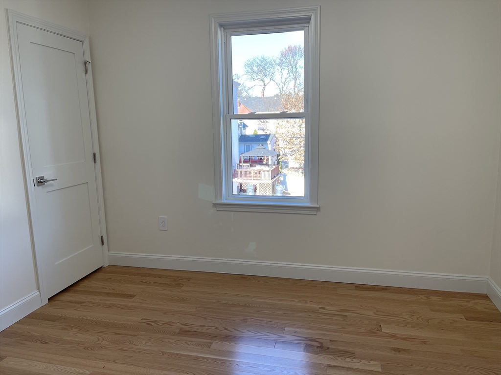 97 Phillips Street, Unit 3 Methuen, MA 01844 - Photo 3 of 9 a view of an empty room with wooden floor and a window