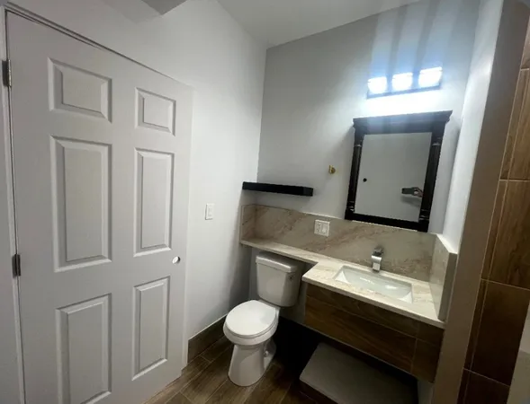 a bathroom with a toilet sink and mirror