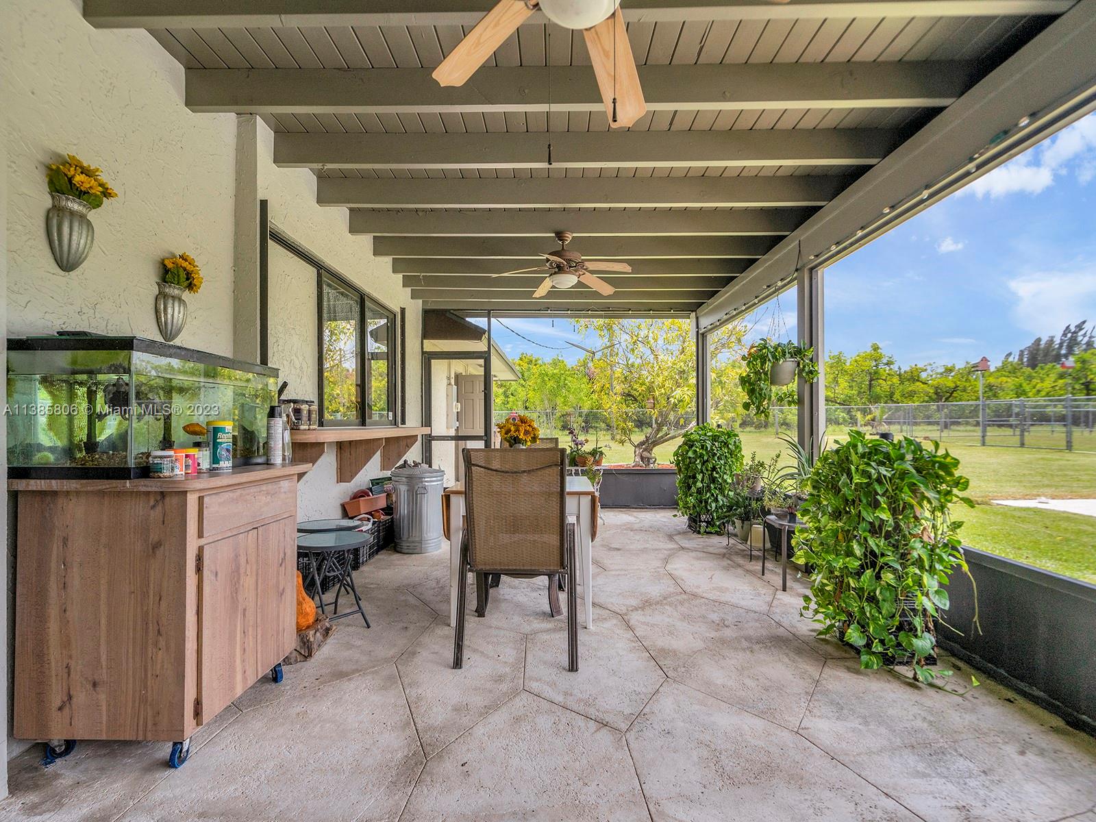 14900 Southwest 250th Street Homestead, FL 33032 - Photo 21 of 34 a view of a patio with table and chairs potted plants with wooden floor