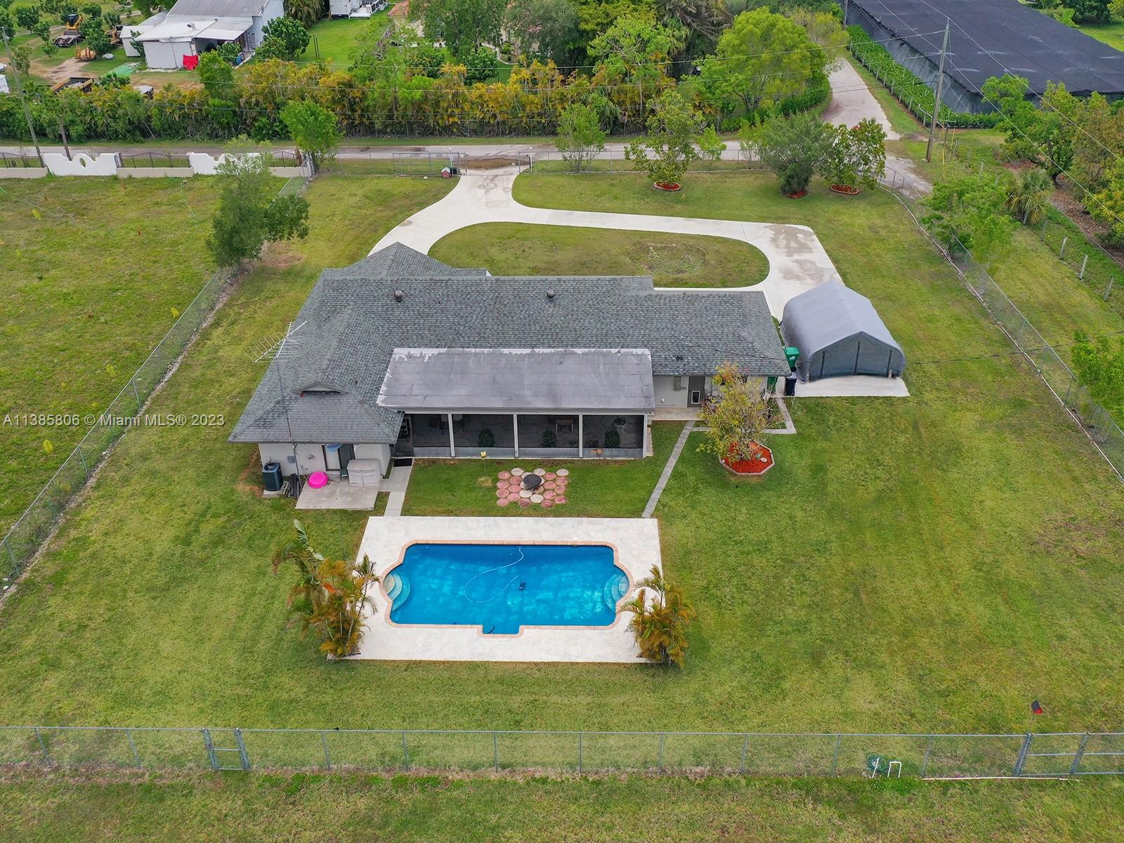 14900 Southwest 250th Street Homestead, FL 33032 - Photo 29 of 34 a aerial view of a house with swimming pool and a yard
