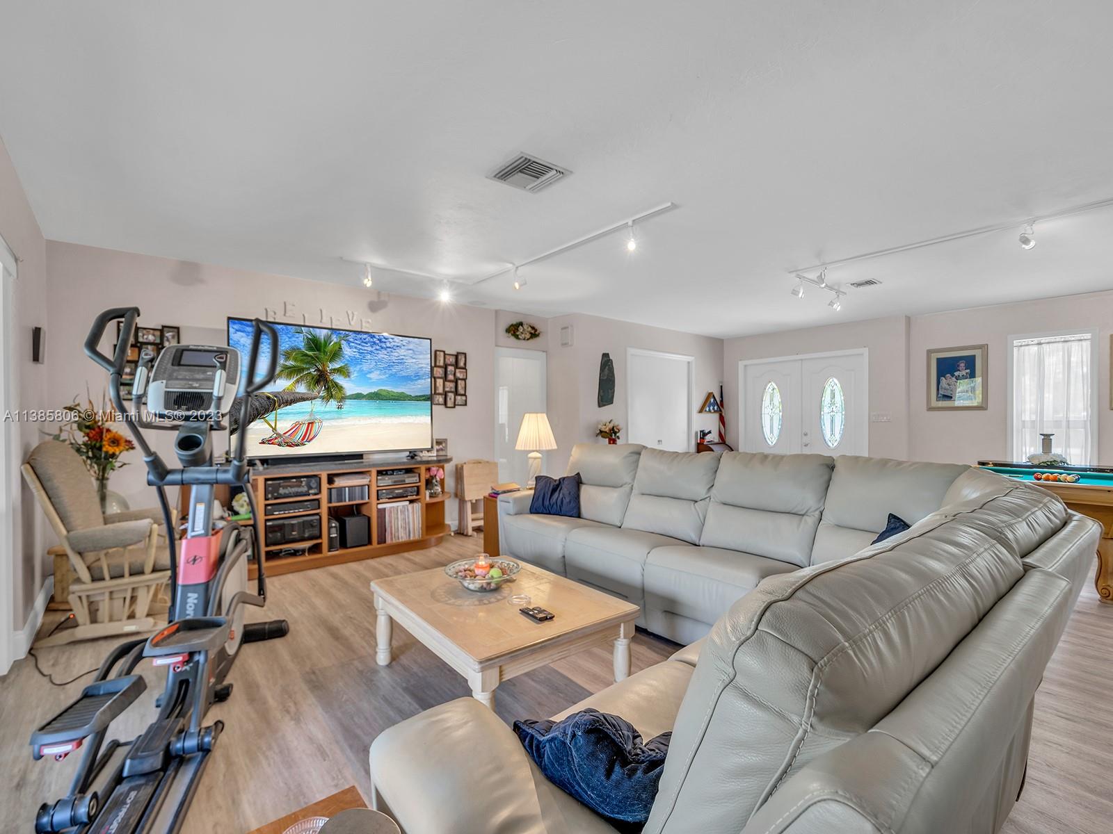 14900 Southwest 250th Street Homestead, FL 33032 - Photo 8 of 34 a living room with furniture a flat screen tv and a large window
