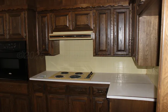 a kitchen with a refrigerator and a stove top oven