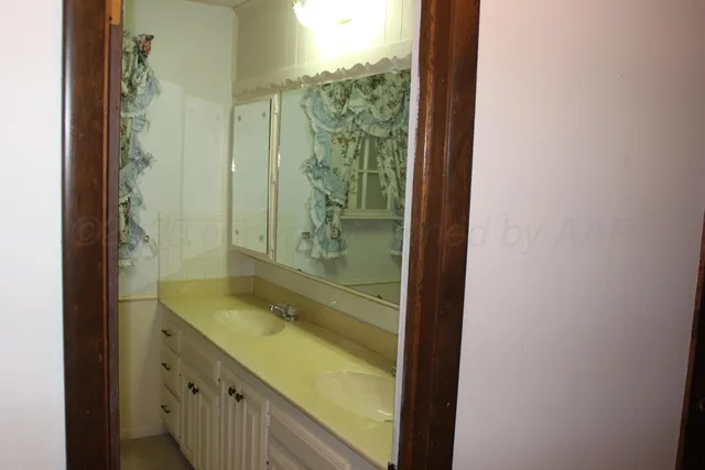 a bathroom with a granite countertop sink a mirror and shower