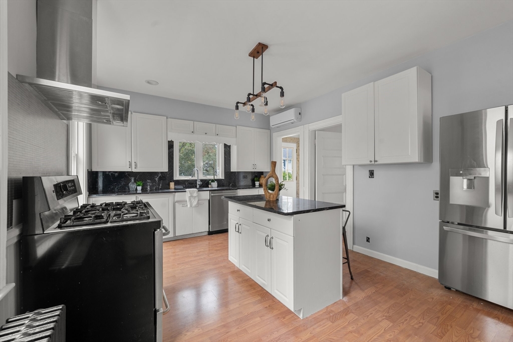 29 Garnet Road Boston, MA 02132 - Photo 14 of 42 a kitchen with stainless steel appliances a stove a sink a refrigerator and white cabinets