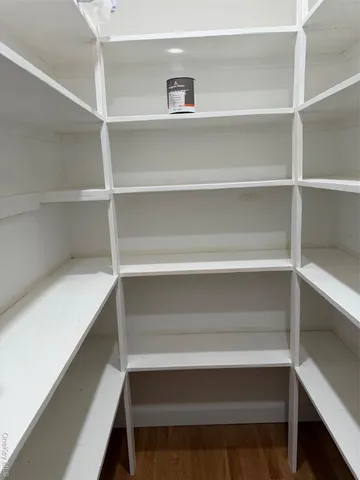 a view of walk in closet with empty racks