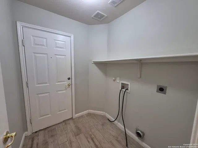 an empty room with wooden floor and cabinet
