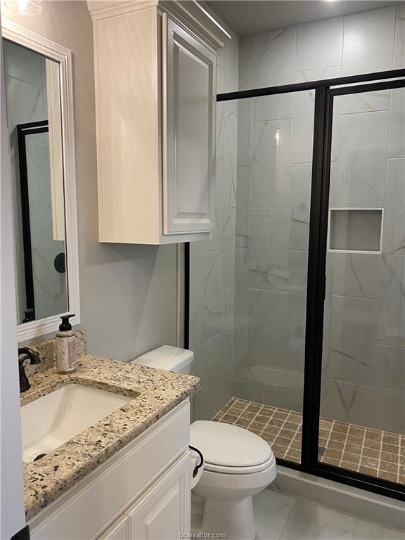 6434 Raleigh Drive College Station, TX 77845 - Photo 18 of 32 a bathroom with a granite countertop sink toilet and shower