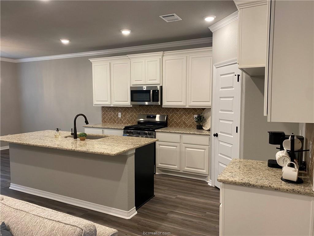 6434 Raleigh Drive College Station, TX 77845 - Photo 6 of 32 a kitchen with stainless steel appliances granite countertop a sink stove and refrigerator