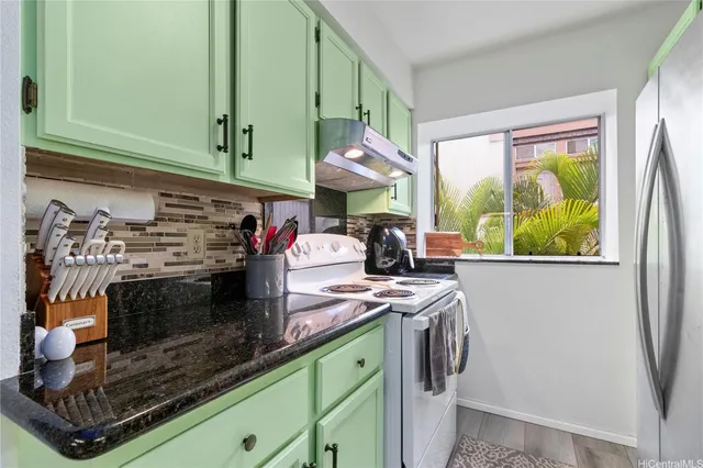 a kitchen with stainless steel appliances granite countertop a stove a sink and a microwave