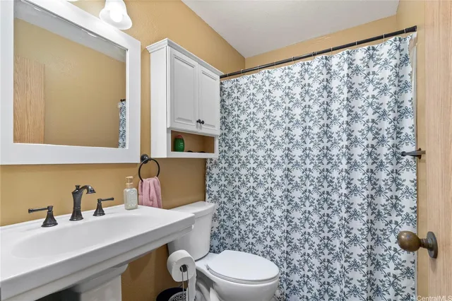 a bathroom with a sink toilet and mirror