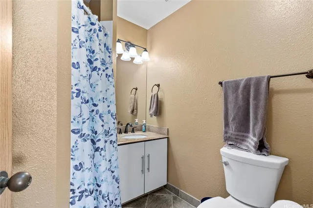 a bathroom with a toilet sink and shower curtain